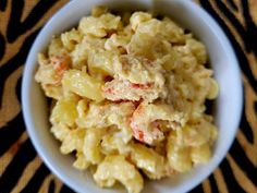 a white bowl filled with macaroni salad on top of a zebra print table cloth