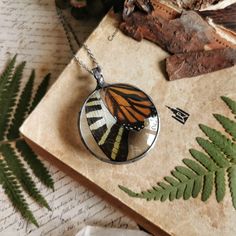 a glass pendant with a butterfly on it sitting on top of a piece of paper