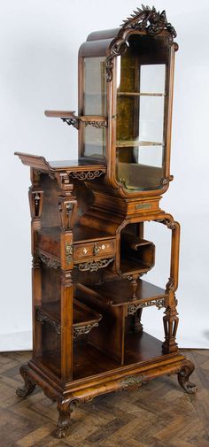 an antique wooden dresser with glass doors and drawers