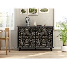 a black and gold sideboard in a room next to a table with two chairs