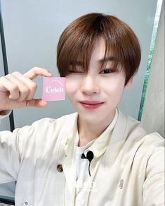 a man holding up a pink card with the word celeb on it