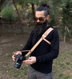 a man with a long beard holding a camera