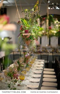 a long table is set with flowers and wine glasses for an elegant dinner or party