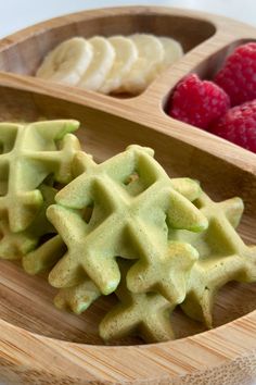 three different types of waffles and raspberries in a wooden bowl