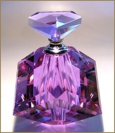 a purple perfume bottle sitting on top of a table