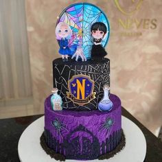 there is a purple cake with two dolls on top and spider web around the bottom