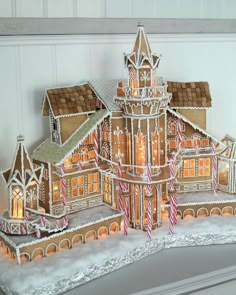 an elaborate gingerbread house is lit up for christmas