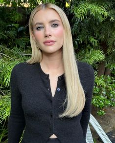 a woman with long blonde hair is posing for the camera