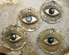 three brass evil eye charms with black stones