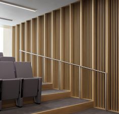 an empty auditorium with rows of seats and wooden slats on the wall behind them