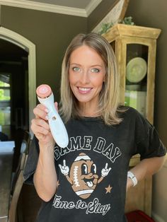 a woman holding a toothbrush in her right hand