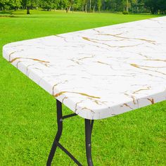 a white table sitting on top of a lush green field