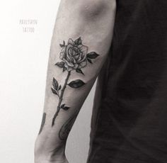 a man with a rose tattoo on his arm