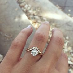 a woman's hand with a ring on it and a diamond in the middle