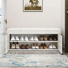 a white bench with shoes on it in front of a wall mounted horse print and framed photograph