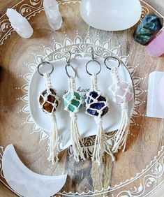 three pieces of jewelry sitting on top of a white plate next to some rocks and crystals