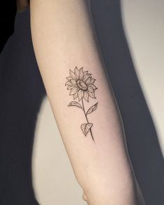 a woman's arm with a sunflower tattoo on the left side of her arm