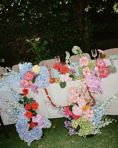 the table is set with flowers and candles for an outdoor wedding reception in the backyard