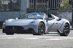 a silver sports car driving down a street next to a traffic light with the word gabetzpuunt written on it