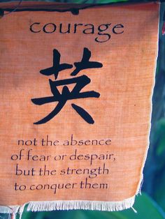 a sign hanging from the side of a tree that says, courage not the presence of fear or despair but the strength to conquer them