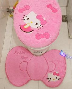 a pink hello kitty toilet seat cover and rug