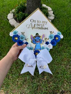 someone is holding up a graduation cap that says on to my next adventure with blue flowers