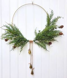 a wreath with pine cones and bells hanging from it