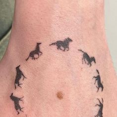 a tattoo on the side of a person's foot with dogs running across it