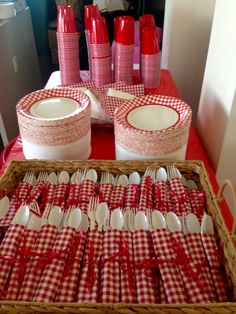 red and white checkered table cloths are arranged in baskets with matching utensils