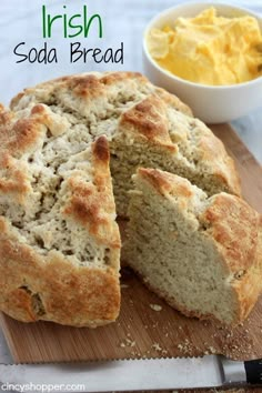 a loaf of irish soda bread on a cutting board next to a bowl of butter