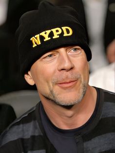 a man wearing a black hat with nypd embroidered on the front and yellow letters on the side