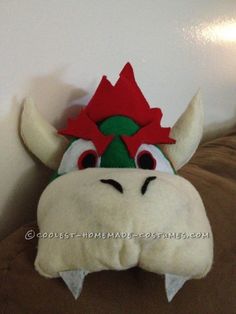 a stuffed animal that is wearing a red and green hat with horns on it's head