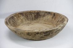 a wooden bowl sitting on top of a white table