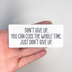 a hand holding a sticker that says, don't give up you can cuss the whole time just don't give up