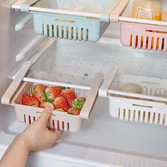 someone is picking strawberries from the fridge