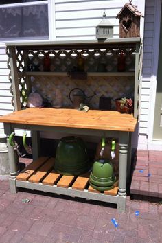 an outdoor potting bench with pots and pans on it