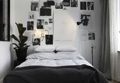 a bed sitting in a bedroom next to a window with pictures on the wall above it