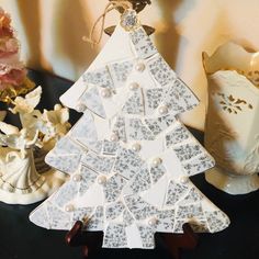 a ceramic christmas tree sitting on top of a table next to vases and flowers