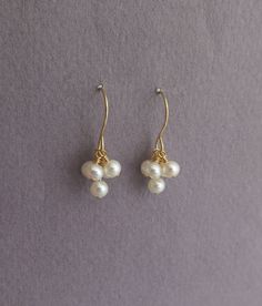 "Gold-filled dangle earrings, dainty earrings with white pearls. Minimalist jewelry for women. These pearl earrings feature a cluster of five white pearls, dangling from 14k gold filled ear wires. Pearl earrings are always classic and elegant. You can wear them for a special occasion as well as for everyday wear. They can make a great gift for bridesmaids or for a June birthday. Pearl is the birthstone for the month of June, it symbolizes purity and is known as the \"stone of sincerity\". Get th Wire Earrings Handmade, Wire Jewelry Earrings, Bridesmaid Pearl Earrings, June Birthstone Jewelry, Jewelry Design Earrings