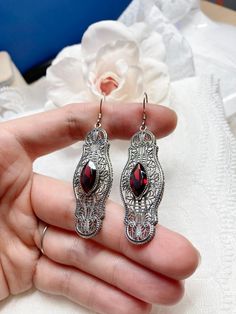 Red Garnet Cubic Zirconia Earrings Iris Design#E2 Custom Made Re-fashioned from an Art Deco pin from the 1920's, I now offer these lovely Antique reproduction earrings in sterling silver. Each stunning bezel set 2.78ct Red Garnet Cubic Zirconia gemstone is 14mm long by 7mm wide. The earrings are 2 1/2 inches long by 11/16th (17mm) wide. Notice the intricate design of the Art Deco filigree setting. A gift box is included and all items are shipped in the box for safe keeping. Feel free to ask ques Ornate Red Drop Earrings, Red Filigree Drop Earrings, Ornate Red Earrings For Party, Ornate Red Filigree Earrings, Victorian Red Oval Earrings, Ornate Red Earrings For Formal Occasions, Red Victorian Jewelry For Evening, Red Garnet Filigree Jewelry, Antique Red Jewelry With Matching Earrings