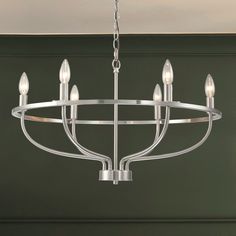 a chandelier with six lights hanging from it's center point in a room