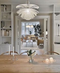 a dining room table with candles and flowers in vases on the centerpiece next to it