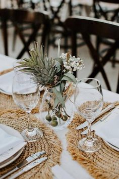 the table is set with place settings, silverware and flowers in glass vases