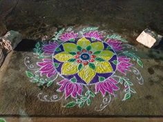 a colorful flower design is painted on the ground with chalk pastel and colored pencils