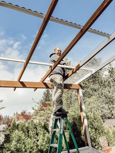 a man standing on a ladder working on a roof