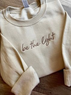 Embroidered "be the light" crewneck sweatshirt,  *custom wording is available : make heaven crowded, faith over fear, walk by faith, wait.pray.trust, made new, etc...! * list your wording in personalization option - check spelling , please no long words as that will effect size of embroidery and include thread color ( font will remain same as shown in main image )!    🧵 THREAD COLORS available : white, black, brown, sand, taupe, golden pecan, charcoal grey, silver grey,  teal, sage, mauve, dark Sweatshirt Embroidery Ideas, Long Words, Make Heaven Crowded, Faith Sweatshirt, Jesus Clothes, Brown Sand, Be The Light, Orange Texas, Embroidery Sweatshirt