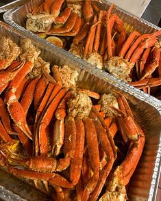 two trays filled with cooked crabs sitting on top of a table next to each other