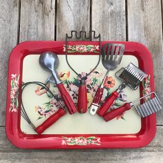 a red tray with utensils and combs on it