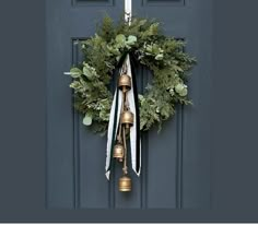 a wreath with bells hanging on the front door