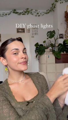 a woman sitting on a couch holding a remote control in her hand with the caption diy ghost lights